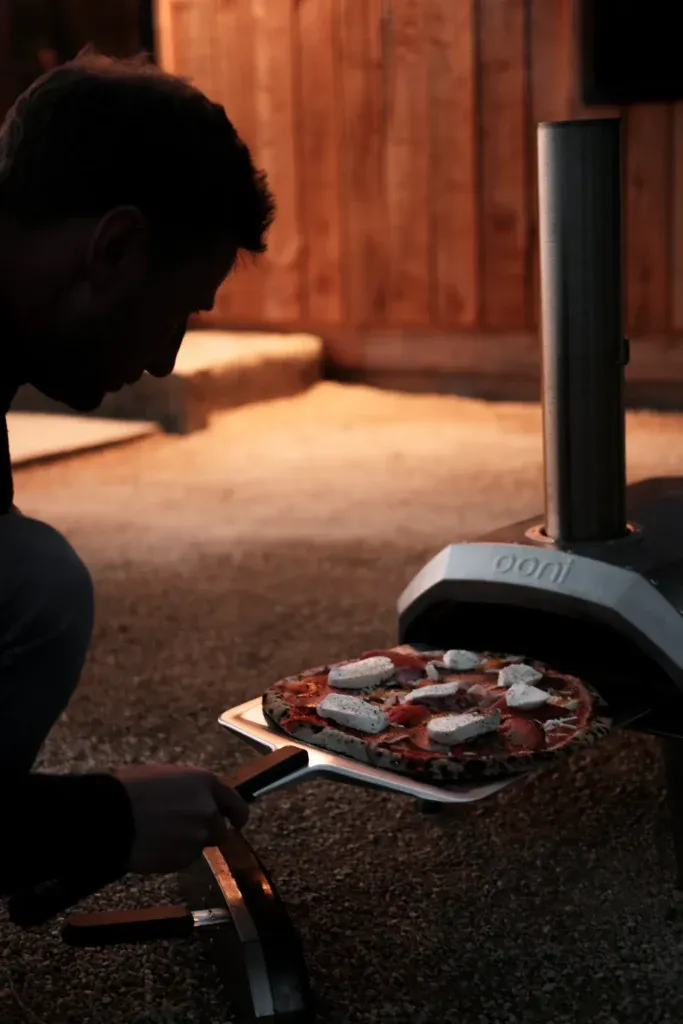 Cooking wood-fired pizza outdoors at The Wild Root
