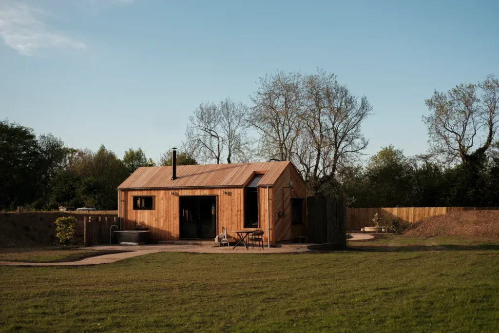Exterior view of timber cabin with outdoor zinc bath in the Chilterns