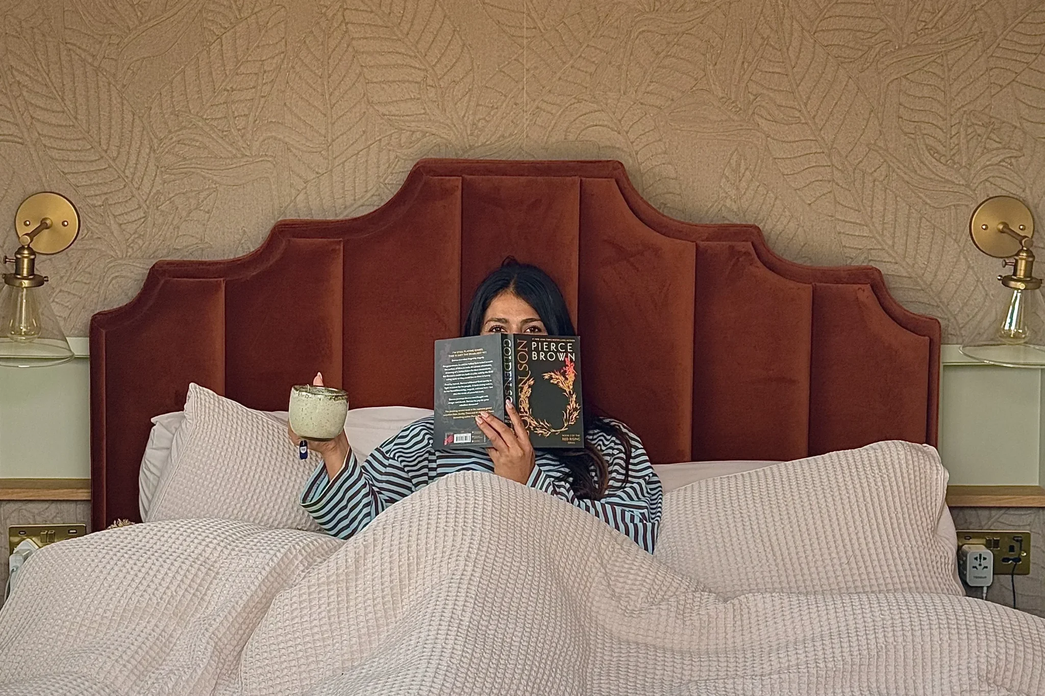 Guest reading in bed with a book